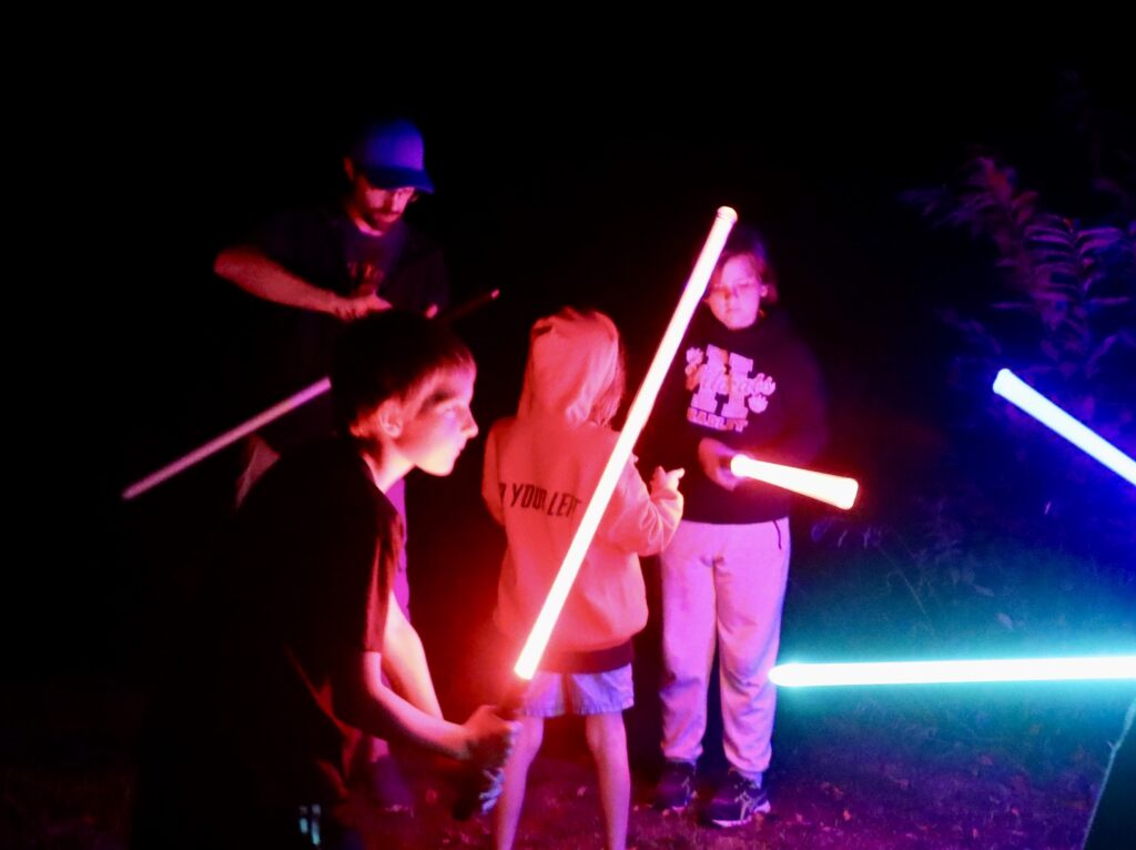 Children holding glowing lightsabers