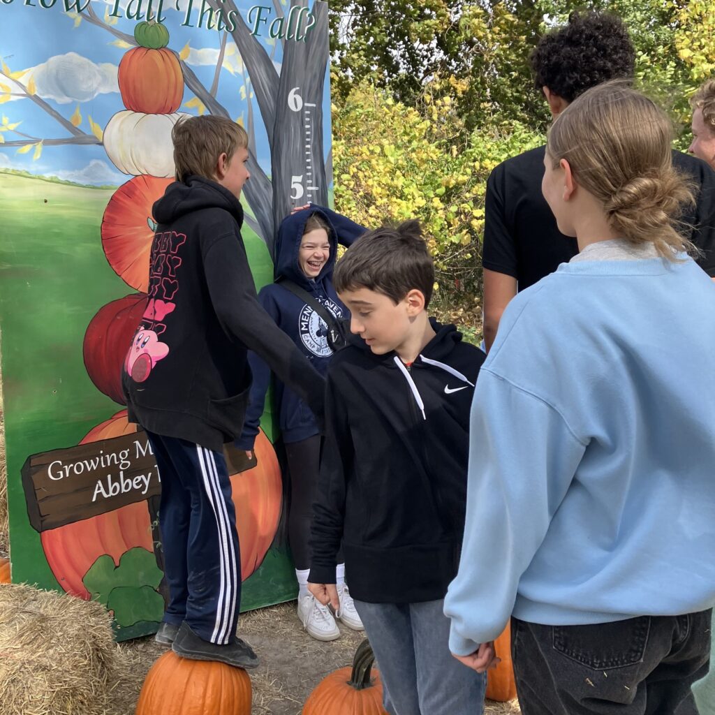 Young teens laugh in a pumpkin patch