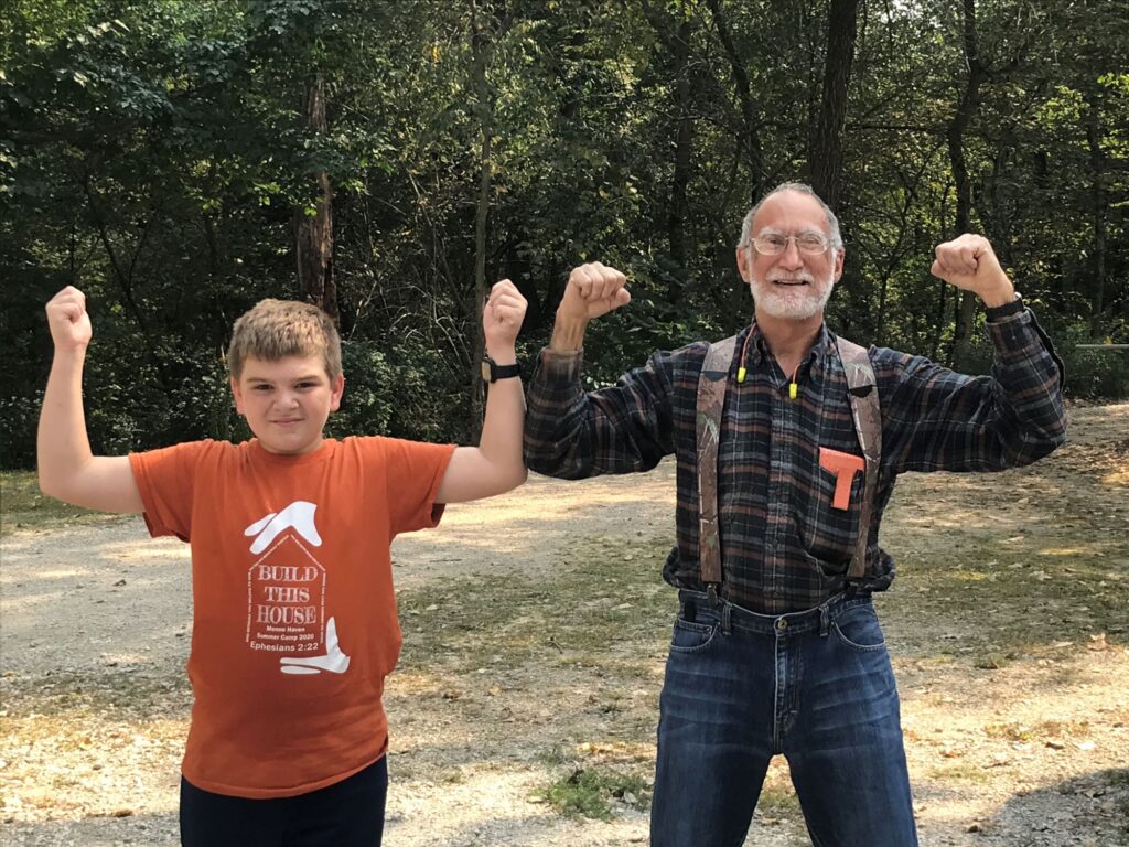 Man and child standing outside in the woods. 