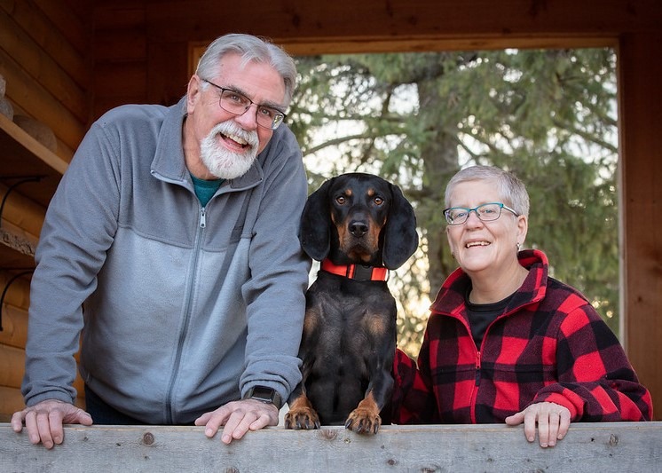 Smiling man and woman with a dog. 