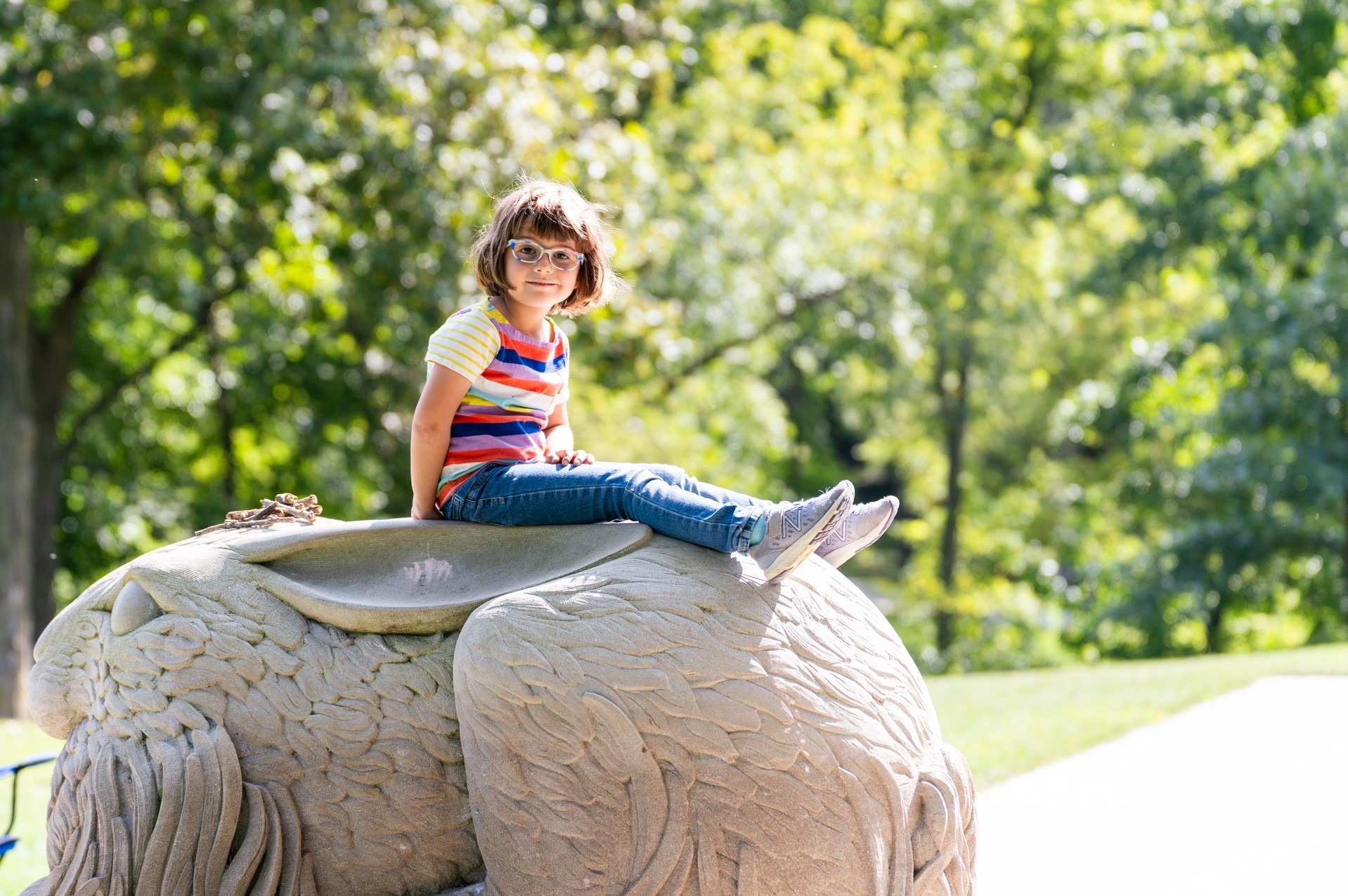 Child on a stone rabbit outdoors