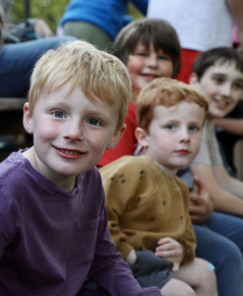 Several young boys smiling on a hayrack ride. 