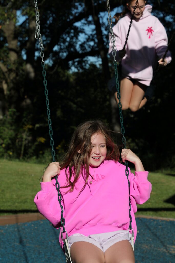 Two girls swinging on a sunny day. 