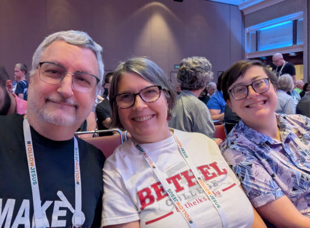 Selfie of a smiling married couple and a friend in a convention workshop. 