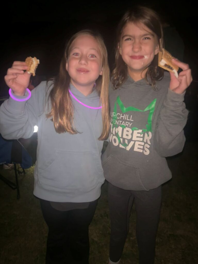 Two girls hold up smores.